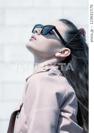 Beautiful woman with long dark hair and sunglasses outdoor close-up portrait 129682576