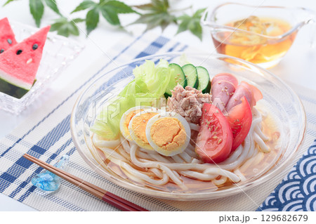 夏にぴったり涼しげなガラス鉢のサラダうどん　野菜と卵とハムを彩りよく盛り付けた冷製麺 129682679