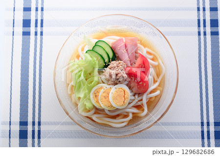 夏にぴったり涼しげなガラス鉢のサラダうどん 野菜と卵とハムを彩りよく盛り付けた冷製麺 夏にぴったり涼しげなガラス鉢のサラダうどん 野菜と卵とハムを彩りよく盛り付けた冷製麺 129682686