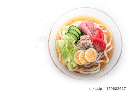 夏にぴったり涼しげなガラス鉢のサラダうどん　野菜と卵とハムを彩りよく盛り付けた冷製麺 129682687