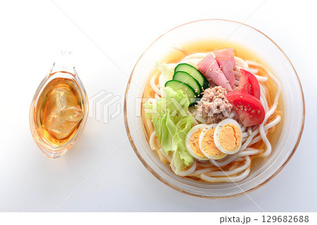 夏にぴったり涼しげなガラス鉢のサラダうどん　野菜と卵とハムを彩りよく盛り付けた冷製麺 129682688