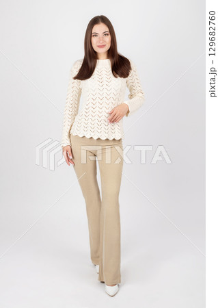 Beautiful woman portrait with white sweater and beige trousers 129682760