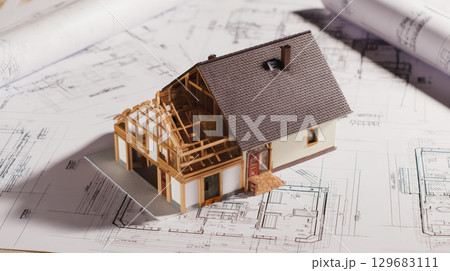 A highly detailed 3D rendering of a house construction project placed over architectural blueprints, representing modern building design, precise planning, and advanced engineering. Generative AI 129683111