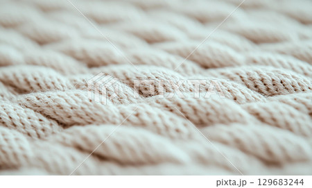 Abstract background Close up of woven fabric showcasing intricate patterns and textures, highlighting craftsmanship and detail in design. soft, natural tones create warm and inviting feel 129683244