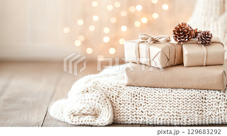 Wrapped holiday festive seasonal Christmas New Year presents gifts with decorative accents create cozy atmosphere, perfect for festive celebrations. soft knit background adds warmth to scene 129683292