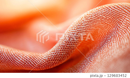 Abstract background Close up of woven fabric with intricate patterns in warm orange tones, showcasing texture and depth. fabric delicate weave creates soft, inviting appearance 129683452