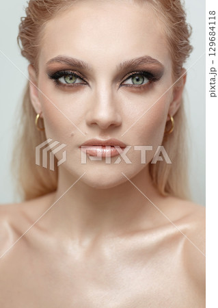 Beautiful woman with smokey makeup close up studio portrait 129684118