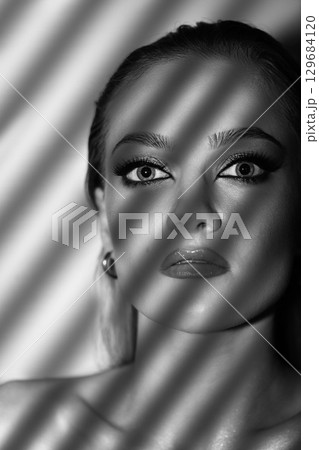 Beautiful woman with smokey makeup close up studio portrait 129684120