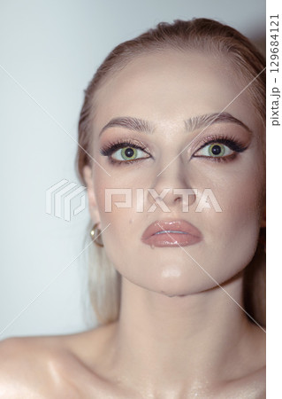 Beautiful woman with smokey make-up close up studio portrait 129684121