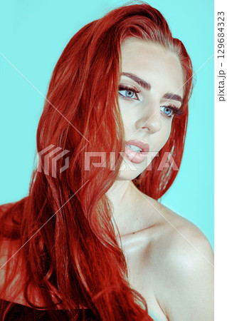 Beautiful woman with smokey make-up and red hair close-up studio portrait Beautiful woman with smokey make-up and red hair close-up studio portrait 129684323