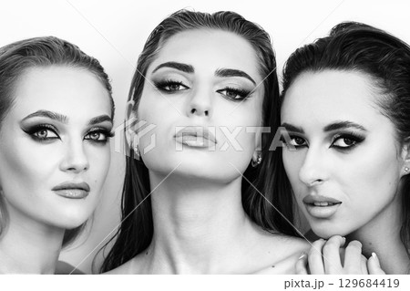 Three beautiful women with smokey make-up and wet hair studio portrait Three beautiful women with smokey make-up and wet hair studio portrait 129684419