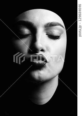Portrait of a young woman sending kiss isolated over black background Portrait of a young woman sending kiss isolated over black background 129684646