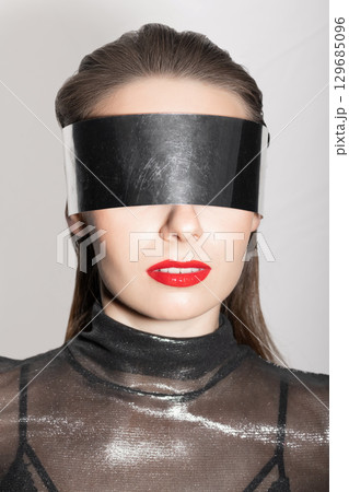 Abstract woman studio portrait with make-up and metallic eyeglasses or helmet covering her eyes Abstract woman studio portrait with make-up and metallic eyeglasses or helmet covering her eyes 129685096