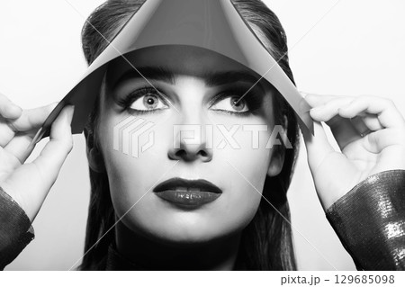 Woman close-up studio portrait covering eyes with plastic hood 129685098