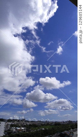 沖縄の街に広がる迫力ある夏空 129685144