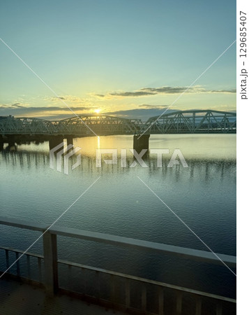 電車から見る朝焼けに染まる荒川と千住新橋 129685407