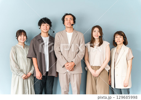 コールセンター,カスタマーセンターで働くインカム,ヘッドセットをつけたオペレーターの男女スタッフ 129685998