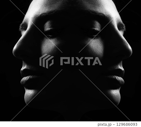 Beautiful woman face silhouette portrait illuminated with light in dark background 129686093