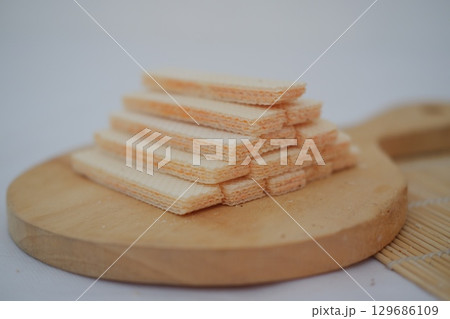 Stack of Crispy Wafer Biscuits on Wooden Board 129686109