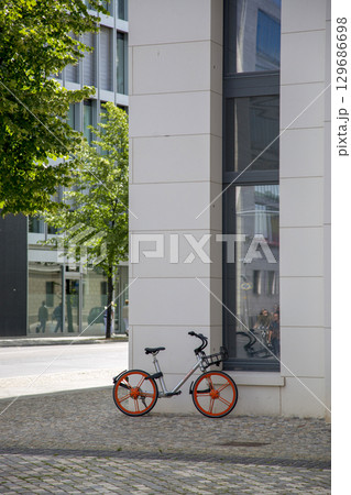 Berlin, Germany - July 01, 2018: Bicycle with red wheels on the sidewalk near the house 129686698