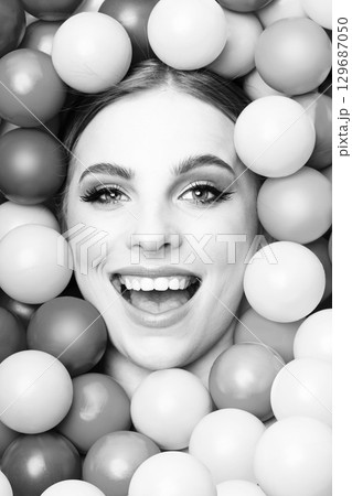 Beautiful woman close-up studio black and white portrait in balls background Beautiful woman close-up studio black and white portrait in balls background 129687050