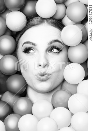 Beautiful woman close-up studio black and white portrait in balls background 129687051