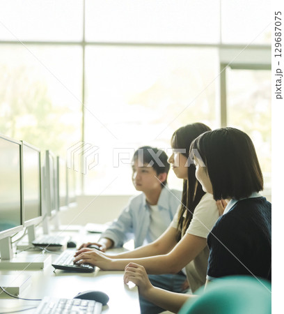 　PC教室でディスカッションする大学生 129687075