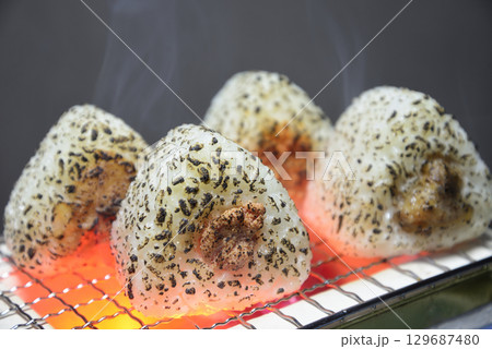 煙りの立ち昇る七輪でお握りを焼く 129687480