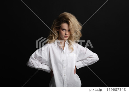 Beautiful woman with big wavy hair and white shirt studio portrait Beautiful woman with big wavy hair and white shirt studio portrait 129687548