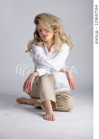 Beautiful woman with big wavy hair studio portrait 129687564