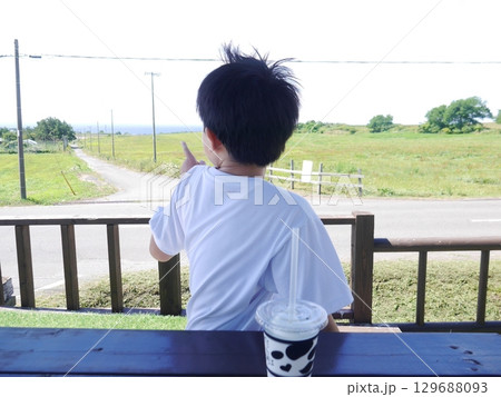 のどかな景色を楽しむ子ども(後ろ姿) 129688093