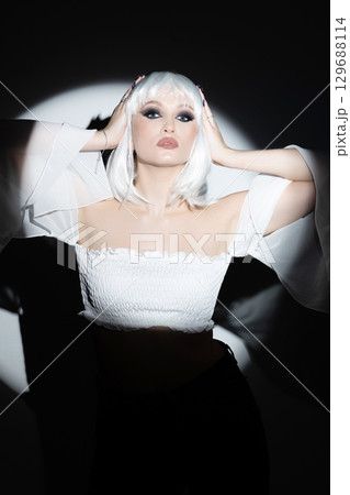 Beautiful woman with white wig portrait illuminated with bright round studio light 129688114