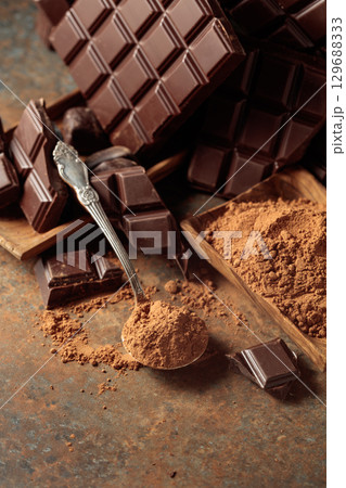 Broken bitter chocolate bar and cocoa powder. 129688333