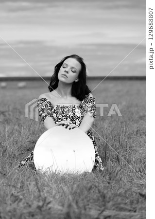 Serene Woman in a Meadow with Mirror 129688807