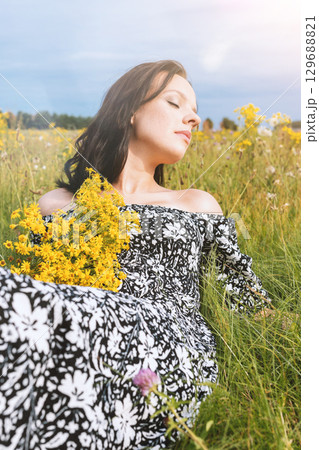 Woman Enjoying Nature in Flower Field 129688821