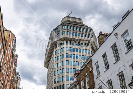 Corporate Building Rising Over Central London Streets, Overcast Sky and Geometric Facade 129689034