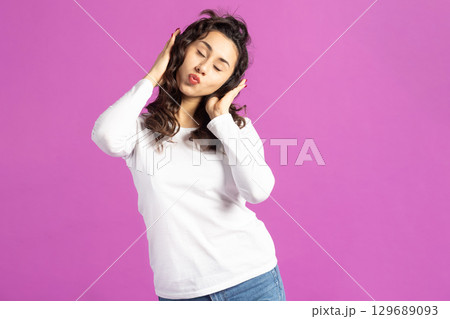 Beautiful woman listening music with headphones 129689093