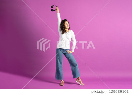 Beautiful woman listening music with headphones 129689101