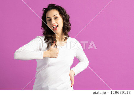 Beautiful woman showing thumb up to camera Beautiful woman showing thumb up to camera 129689118