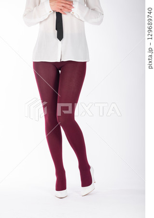 Woman legs with burgundy tights and white high heel shoes Woman legs with burgundy tights and white high heel shoes 129689740