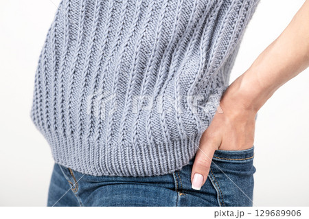 Close-up shot of woman wearing blue sweater and jeans Close-up shot of woman wearing blue sweater and jeans 129689906