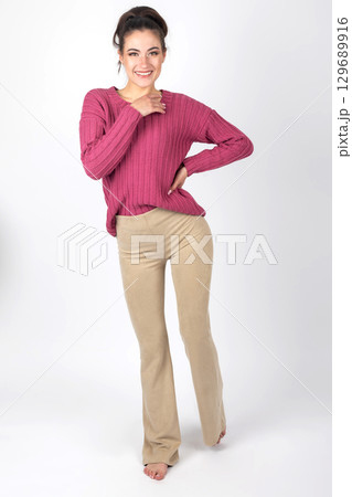 Woman portrait with purple sweater and beige trousers 129689916
