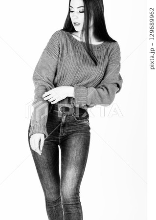 Woman with jeans and sweater studio portrait 129689962