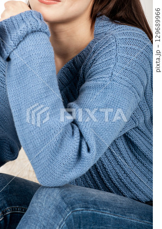 Beautiful woman studio portrait wearing blue sweater and jeans Beautiful woman studio portrait wearing blue sweater and jeans 129689966