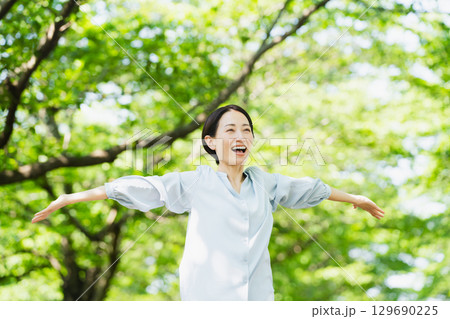 木の下でストレッチをする若い女性　ライフスタイルイメージ 129690225