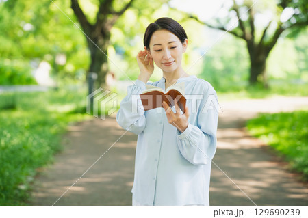 屋外で読書をする若い女性　ライフスタイルイメージ 129690239