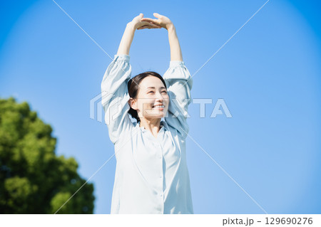 屋外でストレッチをする若い女性　ライフスタイルイメージ 129690276