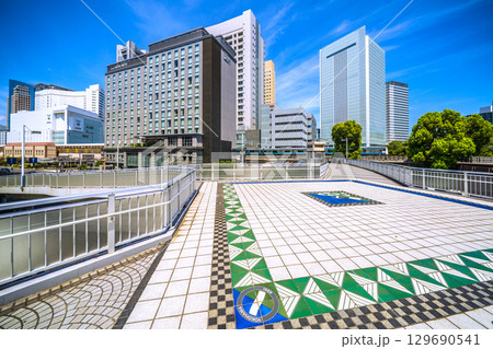 日本の横浜都市景観 桜木町駅　新南口(市役所口）やホテルメッツ、横浜市役所、電車などを桜木橋から望む 129690541