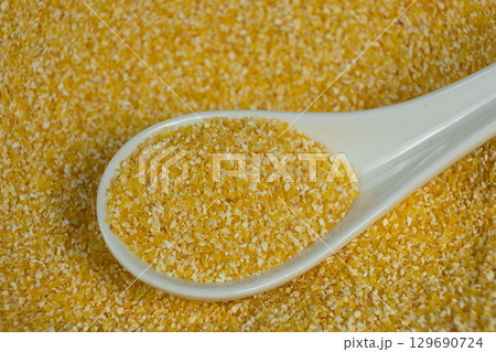 Raw Yellow Corn Grits in a Spoon 129690724