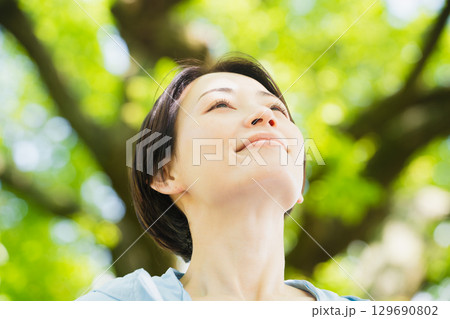 木の下で休憩薄る若い女性　スポーツイメージ 129690802